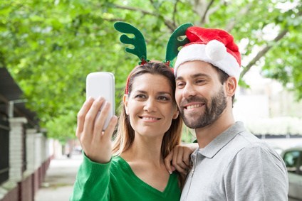 Happy couple taking a picture in Christmas season